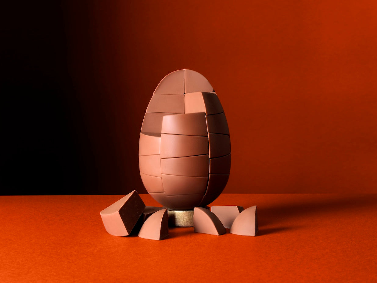 Unpackaged Belgian Milk Caramel Egg on a rich orange background